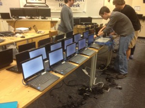 Seniors and members of the 1:1 Student Help Desk Andrew Lobos, Nick Joniec, Collin Enders and Aaron Jandzio (left to right) set up a new batch of 1:1 computers.