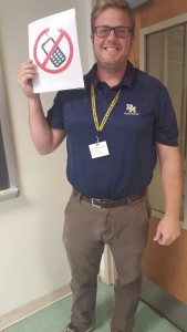 Mr. Staub poses with his no-cell-phone sign. 